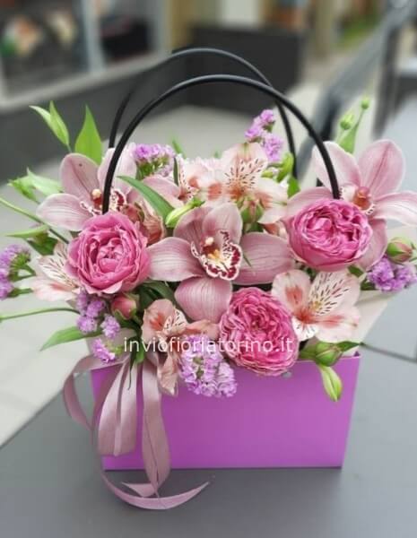 Cestino con orchidee e rose chiare.
